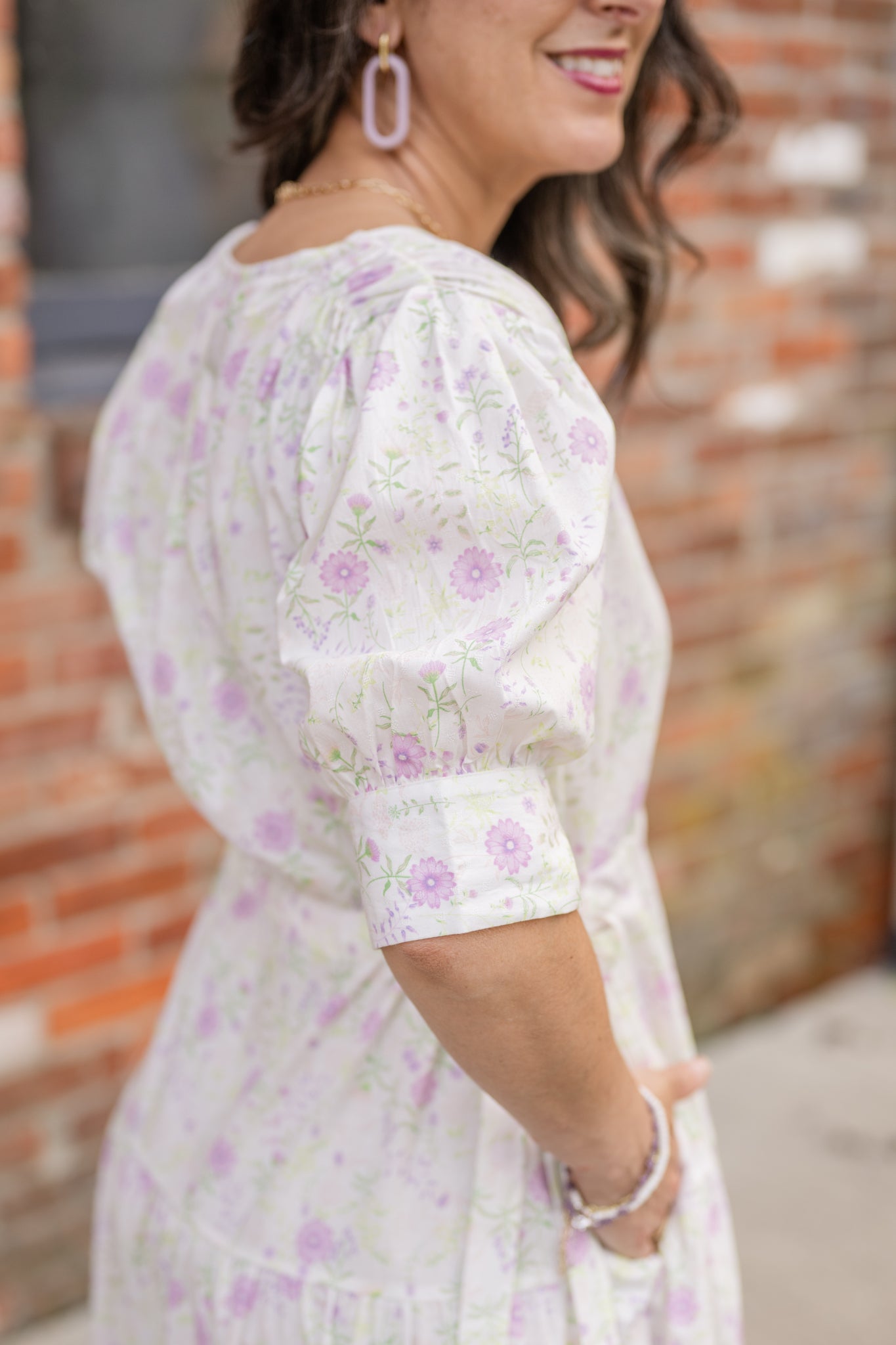 Elegant midi-length dress in surplus 100% cotton with puff sleeves and a unique V-neckline. Features ruching along the bodice, shoulders, and skirt, plus drawstring bows at the waist for a flattering fit. Designed with hidden side pockets, elbow-length keyhole cuff sleeves, and a box-pleated hem. Finished with French seams and a hidden decorative placket.