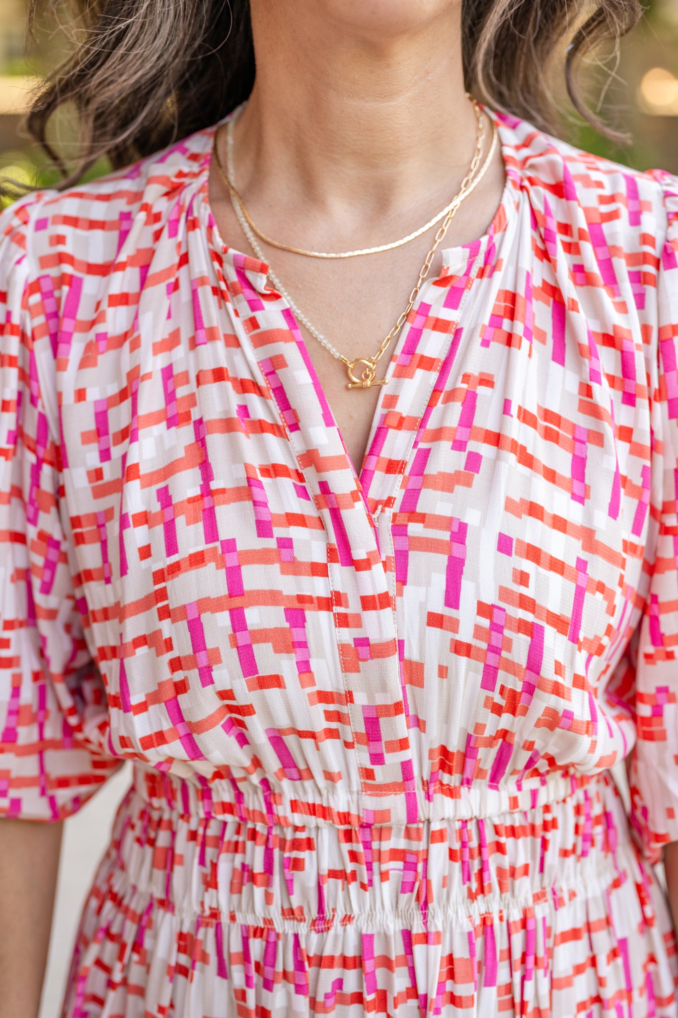 Chic midi dress made from 100% woven viscose surplus fabric, featuring a flattering V-neck with hook-and-eye closures. Designed with a smocked waist for a contoured fit, side slant pockets for convenience, and a pintuck hem between tiers for added texture. Pullover styling with elastic-cuff 3/4 length sleeves, subtle shoulder gathers, and delicate sleeve detailing. A versatile and breathable dress perfect for effortless style.