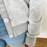 Women's button-front cardigan in lightweight knit fleece cotton blend, available in light grey. Features matching ribbed trims, classic fit, drop-shoulder long sleeves, banded hem & cuffs, and matching buttons. Light-medium weight fabric with slight stretch. Versatile styling. Available in XS-3X.