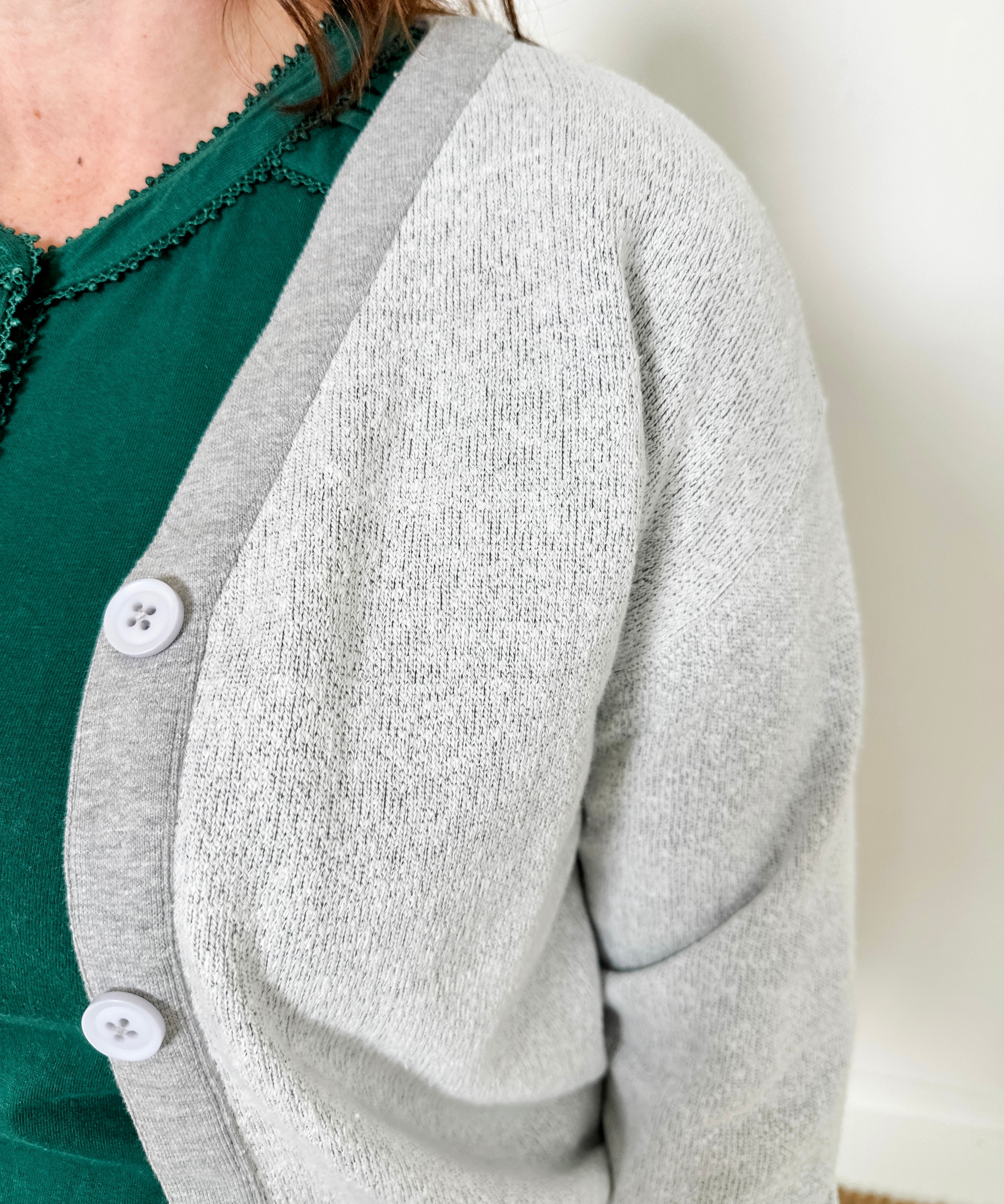 Women's button-front cardigan in lightweight knit fleece cotton blend, available in light grey. Features matching ribbed trims, classic fit, drop-shoulder long sleeves, banded hem & cuffs, and matching buttons. Light-medium weight fabric with slight stretch. Versatile styling. Available in XS-3X.