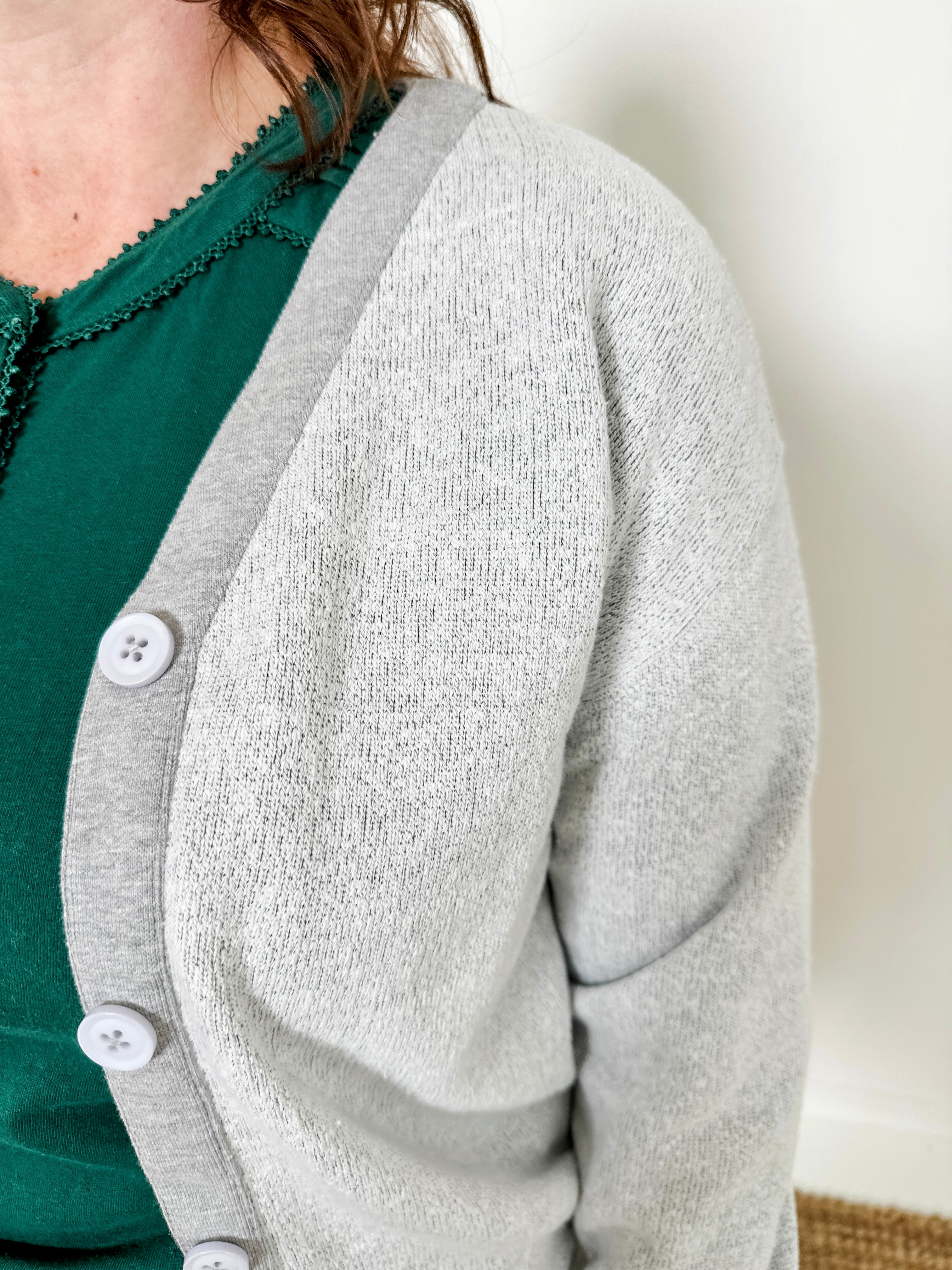 Women's button-front cardigan in lightweight knit fleece cotton blend, available in light grey. Features matching ribbed trims, classic fit, drop-shoulder long sleeves, banded hem & cuffs, and matching buttons. Light-medium weight fabric with slight stretch. Versatile styling. Available in XS-3X.