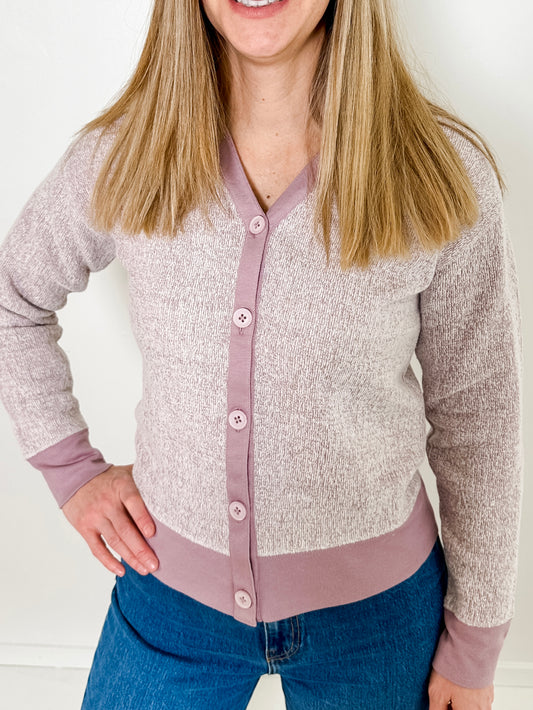 Women's button-front cardigan in lightweight knit fleece cotton blend, available in heathered lavender. Features matching ribbed trims, classic fit, drop-shoulder long sleeves, banded hem & cuffs, and matching buttons. Light-medium weight fabric with slight stretch. Versatile styling. Available in XS-3X.