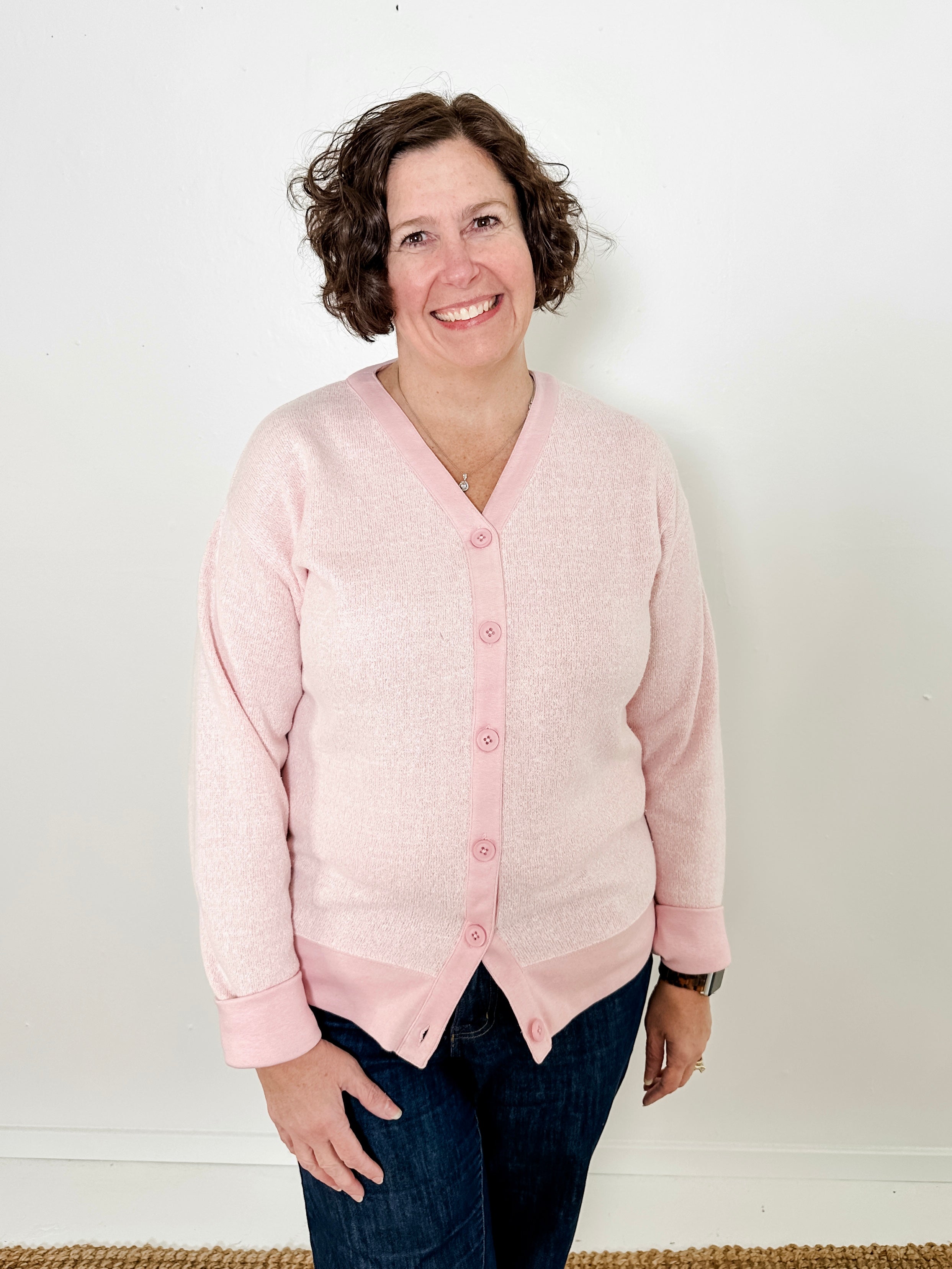 Women's button-front cardigan in lightweight knit fleece cotton blend, available in light pink. Features matching ribbed trims, classic fit, drop-shoulder long sleeves, banded hem & cuffs, and matching buttons. Light-medium weight fabric with slight stretch. Versatile styling. Available in XS-3X.
