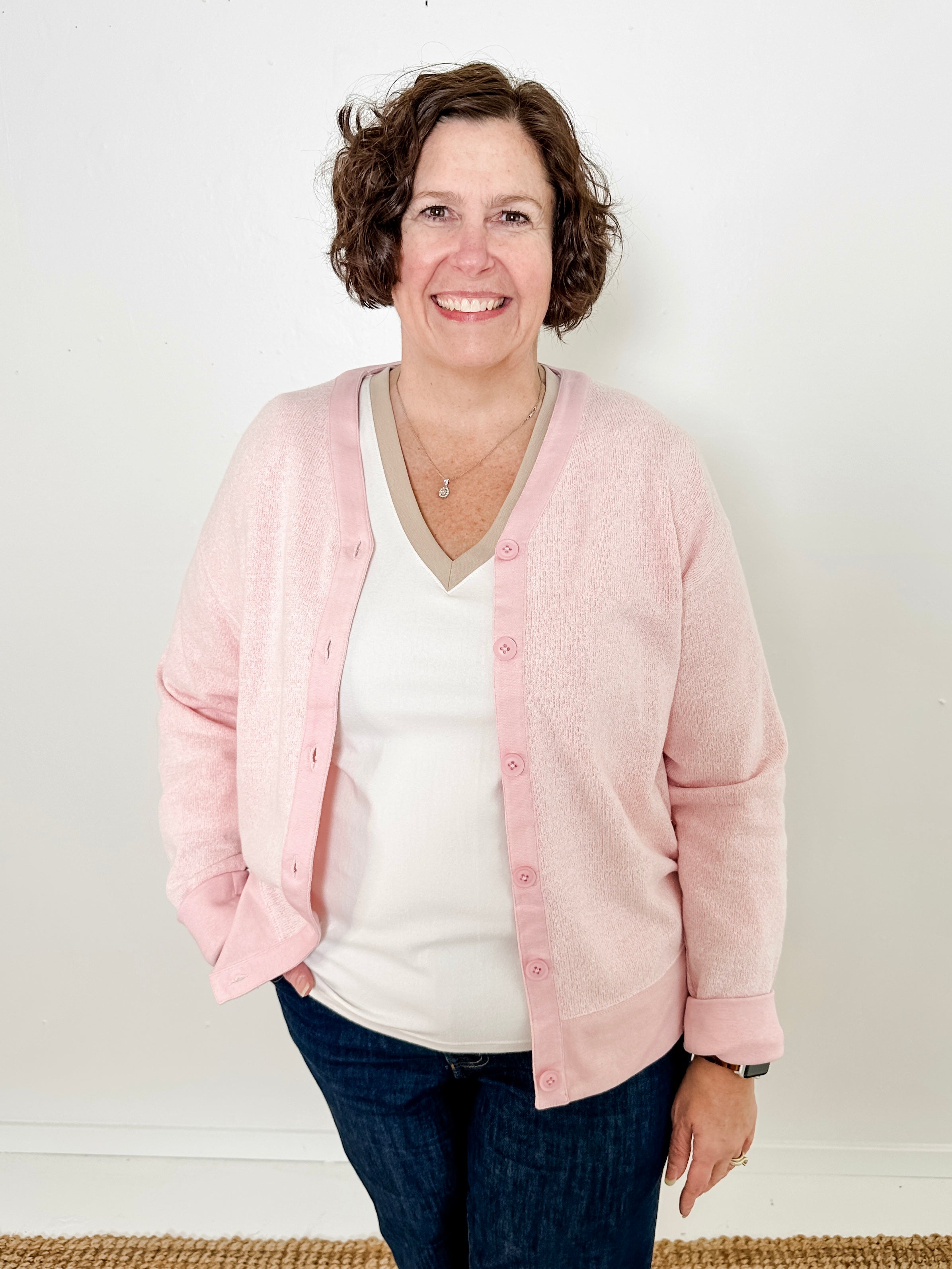 Women's button-front cardigan in lightweight knit fleece cotton blend, available in light pink. Features matching ribbed trims, classic fit, drop-shoulder long sleeves, banded hem & cuffs, and matching buttons. Light-medium weight fabric with slight stretch. Versatile styling. Available in XS-3X.