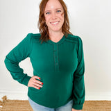 Women's knit blouse with lace detail, made from 100% cotton jersey surplus fabric. Available in Evergreen. Features a collarless band neckline, matching button-front placket, delicate knit lace on shoulders, collar, cuffs, and placket, keyhole buttoned cuffs, and side slits. Medium-weight fabric with light stretch for a straight fit. Available in sizes XS-3X. 