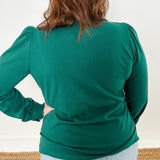 Women's knit blouse with lace detail, made from 100% cotton jersey surplus fabric. Available in Evergreen. Features a collarless band neckline, matching button-front placket, delicate knit lace on shoulders, collar, cuffs, and placket, keyhole buttoned cuffs, and side slits. Medium-weight fabric with light stretch for a straight fit. Available in sizes XS-3X. 