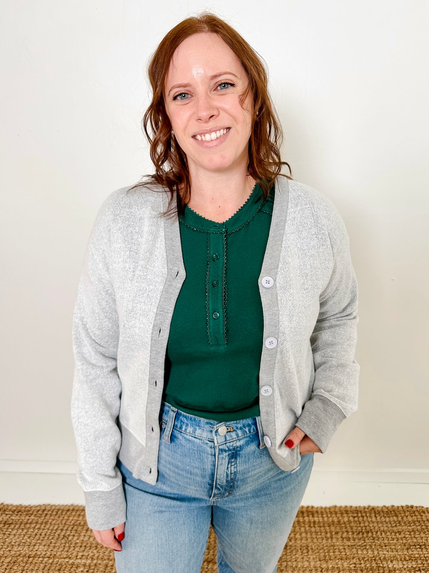 Women's knit blouse with lace detail, made from 100% cotton jersey surplus fabric. Available in Evergreen. Features a collarless band neckline, matching button-front placket, delicate knit lace on shoulders, collar, cuffs, and placket, keyhole buttoned cuffs, and side slits. Medium-weight fabric with light stretch for a straight fit. Available in sizes XS-3X. 