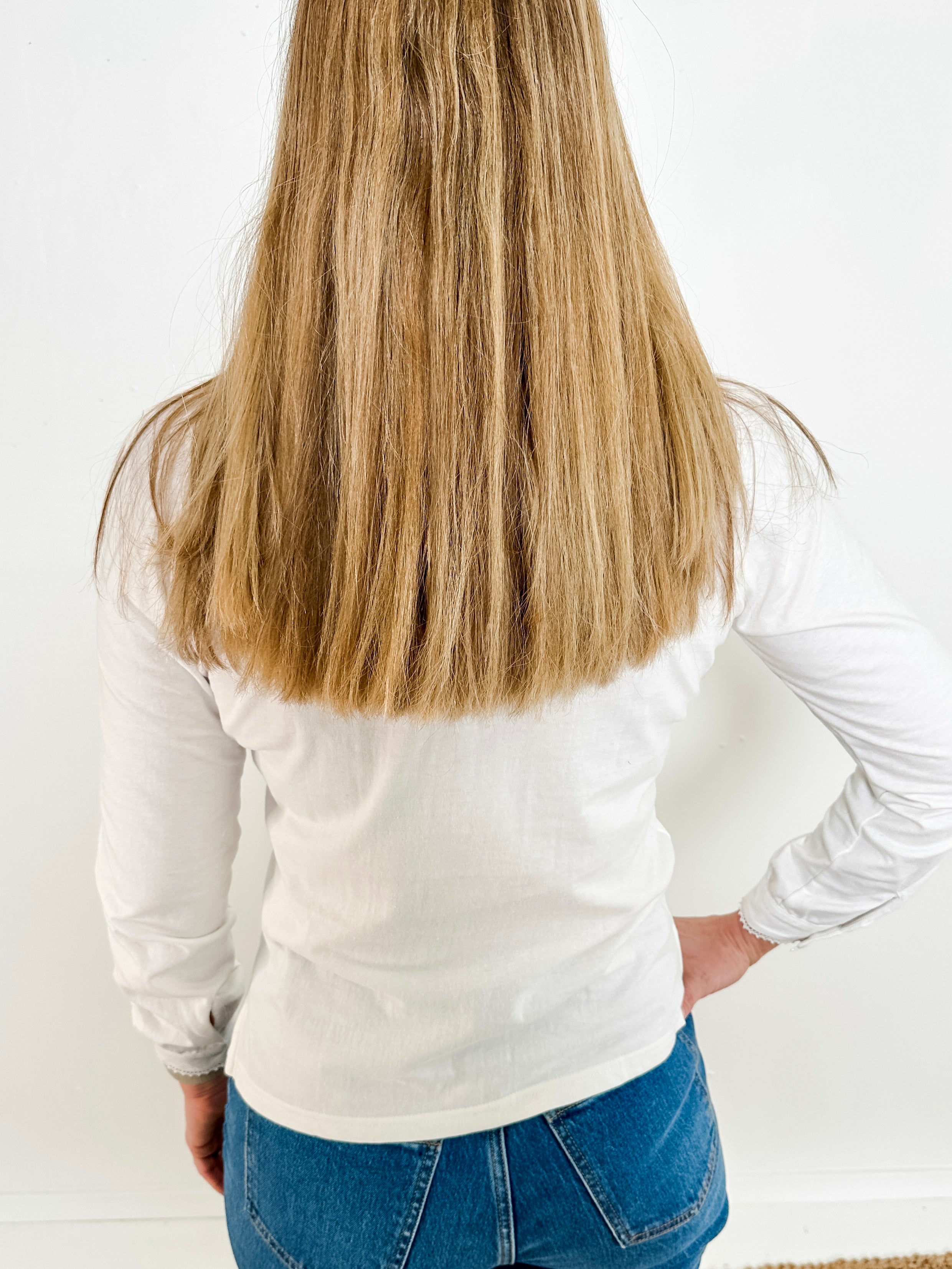 Women's knit blouse with lace detail, made from 100% cotton jersey surplus fabric. Available in white. Features a collarless band neckline, matching button-front placket, delicate knit lace on shoulders, collar, cuffs, and placket, keyhole buttoned cuffs, and side slits. Medium-weight fabric with light stretch for a straight fit. Available in sizes XS-3X. 