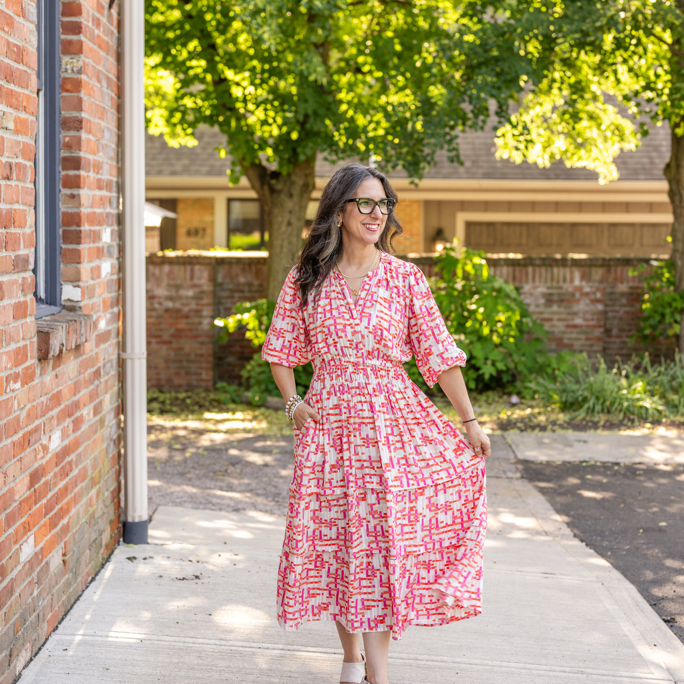 Chic midi dress made from 100% woven viscose surplus fabric, featuring a flattering V-neck with hook-and-eye closures. Designed with a smocked waist for a contoured fit, side slant pockets for convenience, and a pintuck hem between tiers for added texture. Pullover styling with elastic-cuff 3/4 length sleeves, subtle shoulder gathers, and delicate sleeve detailing. A versatile and breathable dress perfect for effortless style.