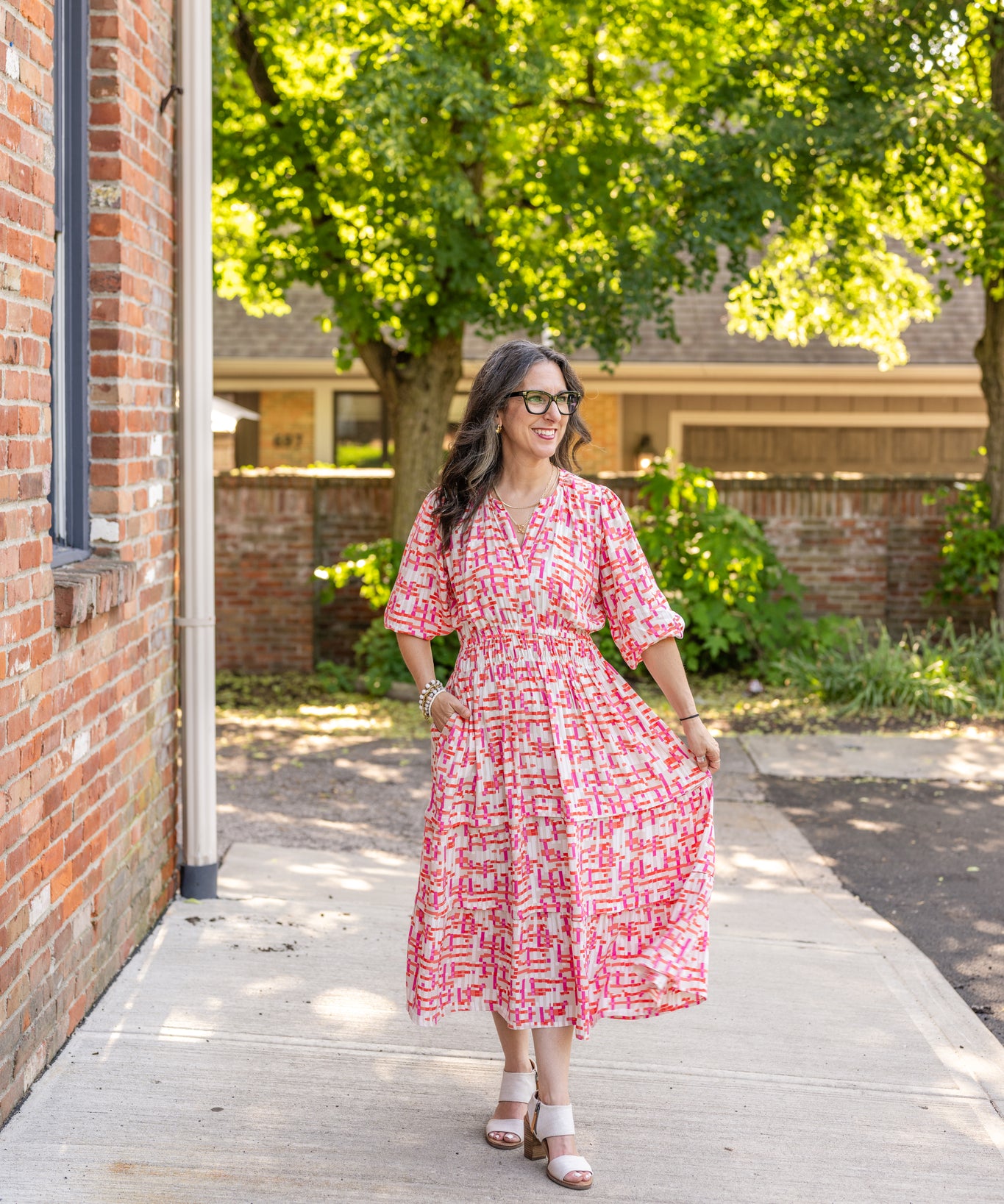 Chic midi dress made from 100% woven viscose surplus fabric, featuring a flattering V-neck with hook-and-eye closures. Designed with a smocked waist for a contoured fit, side slant pockets for convenience, and a pintuck hem between tiers for added texture. Pullover styling with elastic-cuff 3/4 length sleeves, subtle shoulder gathers, and delicate sleeve detailing. A versatile and breathable dress perfect for effortless style.