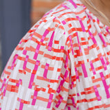 Chic midi dress made from 100% woven viscose surplus fabric, featuring a flattering V-neck with hook-and-eye closures. Designed with a smocked waist for a contoured fit, side slant pockets for convenience, and a pintuck hem between tiers for added texture. Pullover styling with elastic-cuff 3/4 length sleeves, subtle shoulder gathers, and delicate sleeve detailing. A versatile and breathable dress perfect for effortless style.